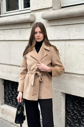 a lady wears a camel wool coat with black pants